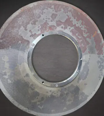 Partially cleaned stainless steel industrial filter during restoration.