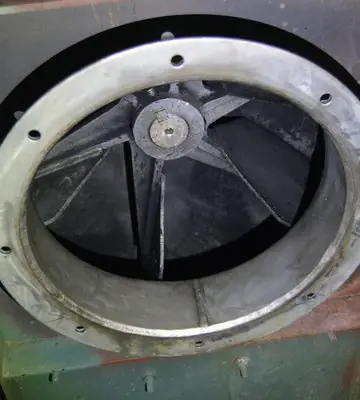Circular industrial machine opening and surrounding flange after soot and fire residue cleaning.