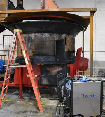 Large red industrial hay grinder with ladder and dry ice blasting equipment positioned for fire-remediation work.
