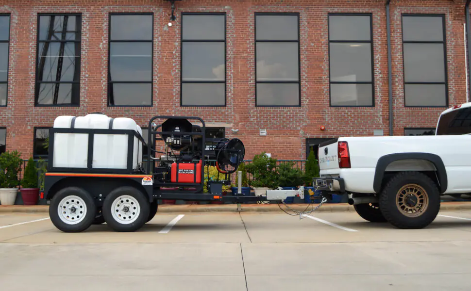 Merritt Industrial pressure washing trailer and service truck outside a commercial building in Charlotte, NC.
