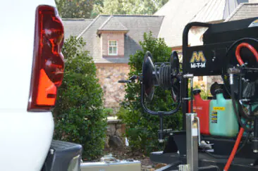 Close-up of pressure washing hose reels and equipment mounted on a mobile trailer.